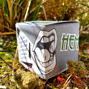 Hemp paper packaging photographed outdoors with cannabis.
